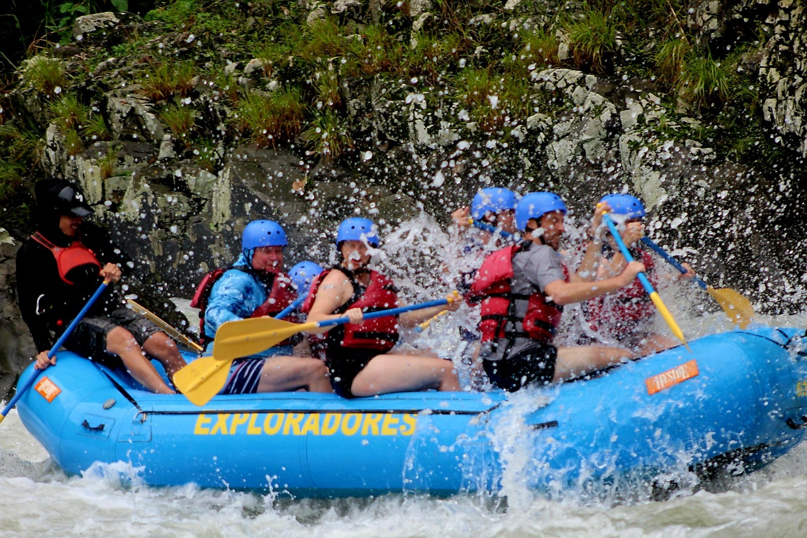 Mid-rapid chaos — paddles digging in, water flying, and absolutely no way to stay dry. This is whitewater rafting in Costa Rica at full throttle.