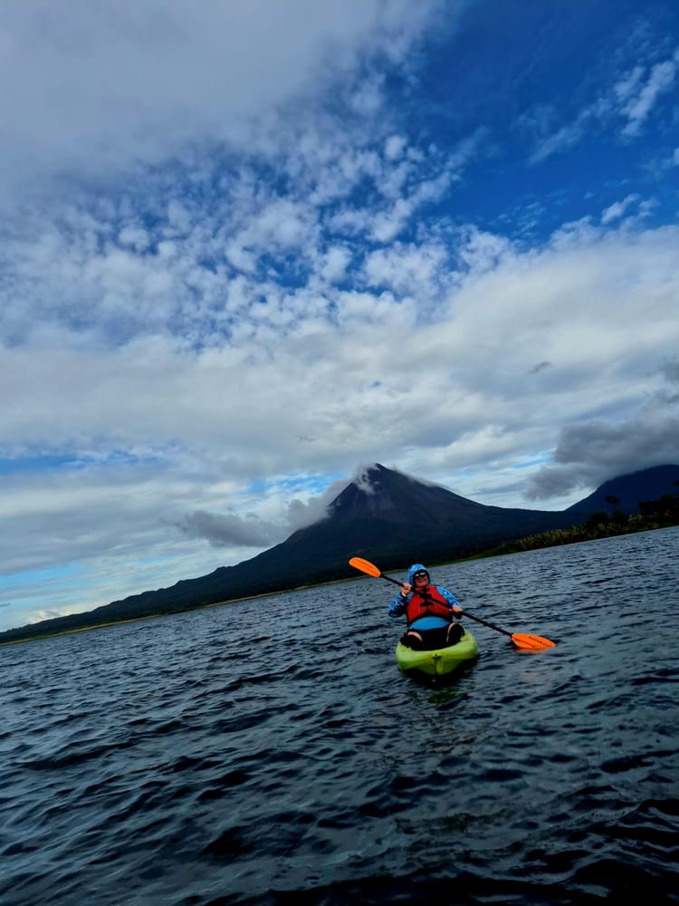 Kayaking on Lake Arenal — steady paddling, shifting weather, and the volcano watching quietly from behind.